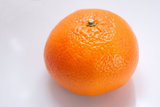 whole fresh orange over a light background