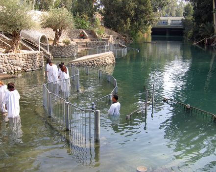 Baptism of pilgrims conducted by a pastor in the Jordan River Holyland Israel