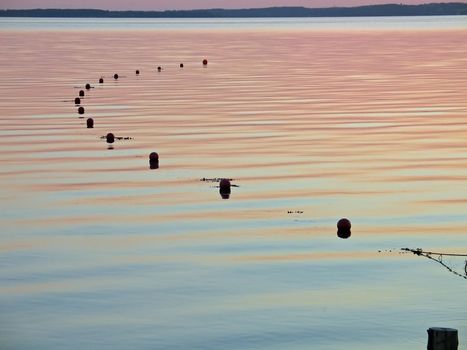 Calm sea with big fishing net connected to buoys ready for the catch