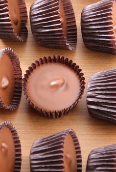 A group of peanut butter cups on a wood counter top.