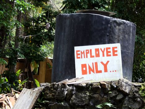 A homemade employee only sign at a  old distillery. 