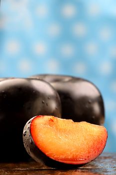 Fresh black plum slice on a stone counter.