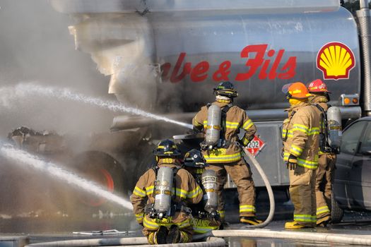 Granby, Quebec, Canada, March 10th, 2010 - Firemen fighting a fire on tank trucks
at a gas station