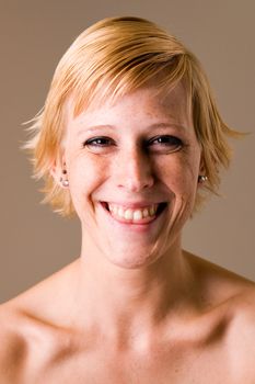 Studio portrait of a short haired blond girl clearly having fun