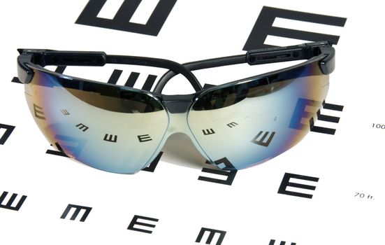 sunglasses laying on an eye exam chart background