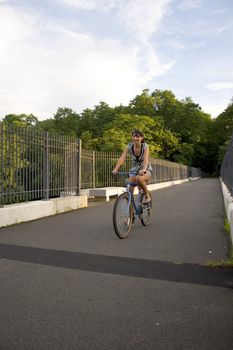 A young woman riding her bike outdoors.