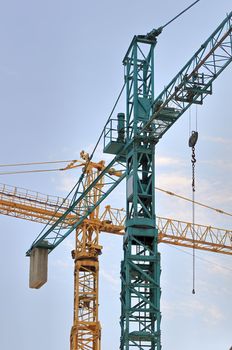 Yellow and green cranes against the sky