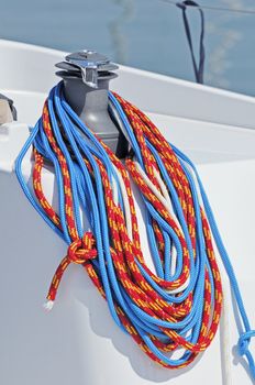 Coloured ropes wrapped on a winch of a boat