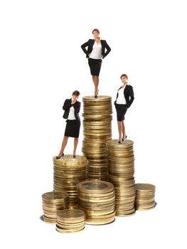 Young attractive businessladies on coin towers concept isolated on white     