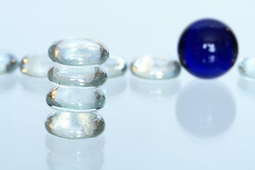 Stack of four glass stones on backround with glass balls lying in a row