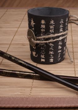 Japanese bowl with chopsticks over dark background       