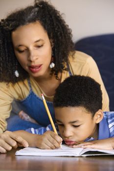 Portrait of mom helping son with homework.