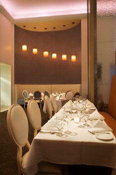 Long table in restaurant with place settings.