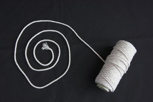 Roll of rope forming spiral on a black background