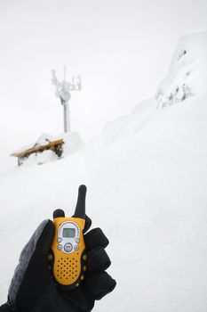 Gloved hand holding walkie talkie.