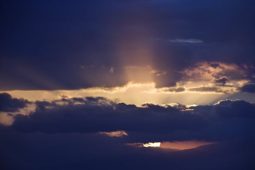 Sunbeams coming through clouds at sunrise over Maui, Hawaii, USA.