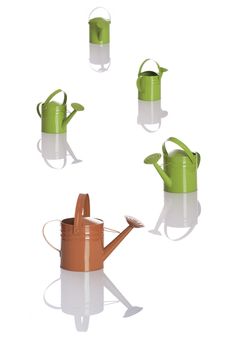 Multiple watering cans in DOF on a white background with reflection