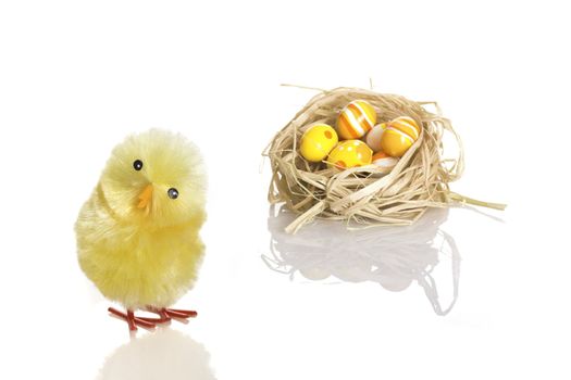 Young Easter chicken toy and a nest with painted eggs