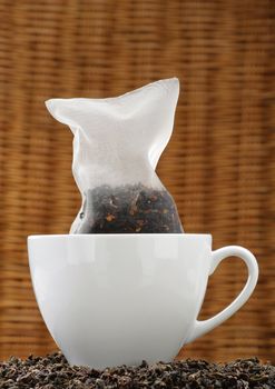 Organic tea in a corn silk tea bag in a white cup.