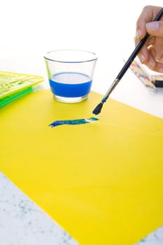 Brush, paints, sheet on table. Preparation for drawing.