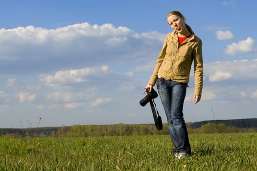 Young girl with camera on green grass