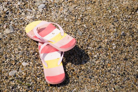 two colorful slippers on the beach