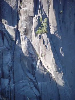 The morning sun casting its light on a white granite cliff.