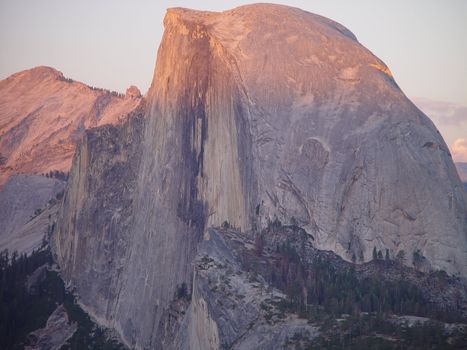 The alpine glow of sunset hits Yosemite National Parks Half Dome.