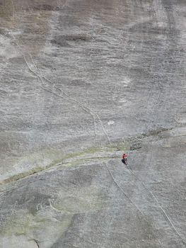 A man climbing a granite cliff.