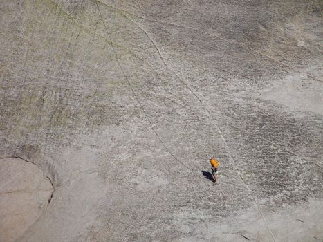 A man climbing a granite cliff.