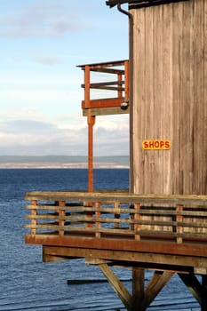 A sale sign on the side of a coastal store in a rural setting.