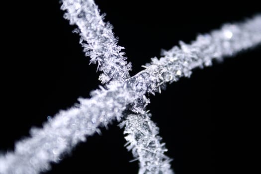 A very up-close image of frost crystals on a black background.