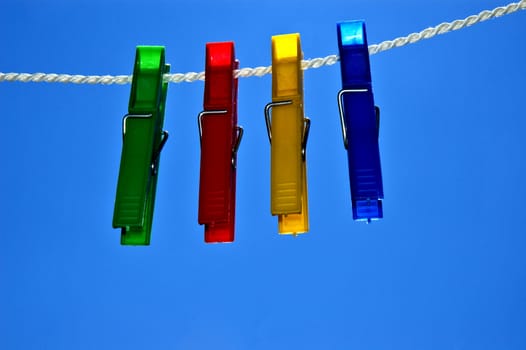 Green, red, yellow and blue clips on rope.