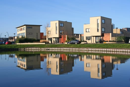 Three houses and their reflections in a modern suburb