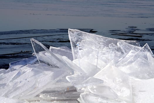 Brocken ice shinning in the winter sun and reflecting the blue sky.