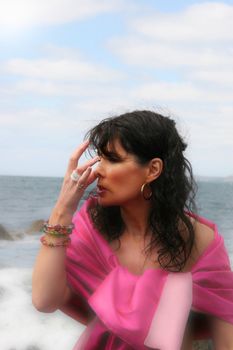 beautiful woman meditating on the rocks in ireland with her eyes closed, in the lotus position, showing a healthy way to live a happy and relaxed lifestyle in a world full of stress