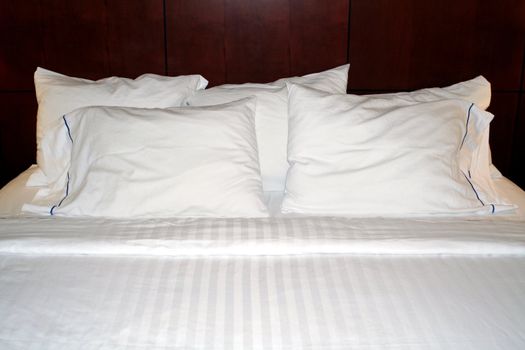 A hotel bed with clean white linens.