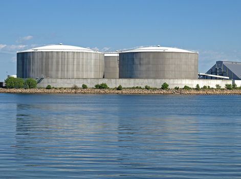 three circular industrial tanks built near the coast