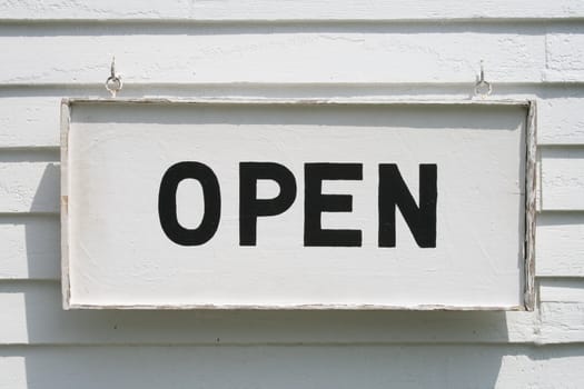 A welcoming old Open sign, black letters on white background