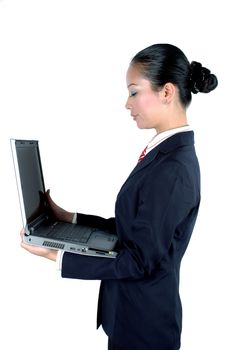 Chinese businesswoman busy with work, holding laptop, wearing elegant suit.