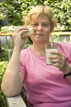 elderly woman is eating lunch in the garden