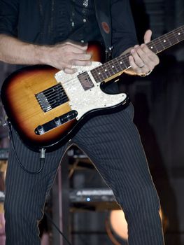 Detail of electric guitar being played during rock live event