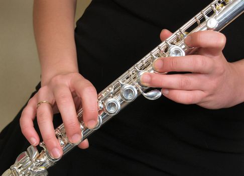 flute of classical orcherstra. hands on silver musical instrument