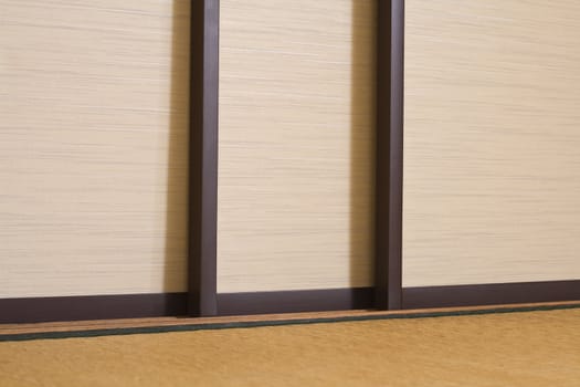 Specific detail of sliding doors in a traditional Japanese house.In front of the doors the floor is represented by a tatami. 