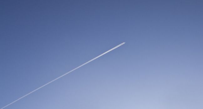 Image of airplane traces on a dark blue sky.