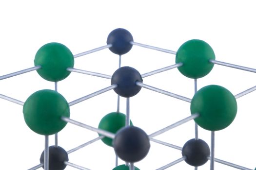 Image of a network of atoms, part of a NaCl molecule, isolated against a white background.