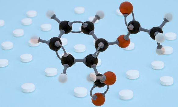 Spatial molecular structure of Aspirin (acetylsalicylic acid) blending with a background made of a lot of aspirin pills. 