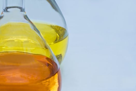 Laboratory flasks containing an orange and yellow solutions (soft focus).