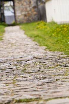 Shot of a cobbled footpath ending at an open door. Interesting perspective and extremely selective artistic focus somewhere on the path. The rest is blurred enhancing the general idea of this image: destiny...Shot with Canon 70-200mm f/2.8L IS USM