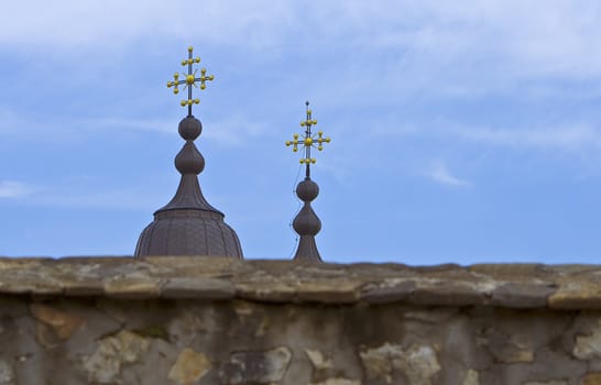 The spires of a Romanian monastery (Varatec-Moldavia) showing above the surrounding wall.Shot with Canon 70-200mm f/2.8L IS USM
